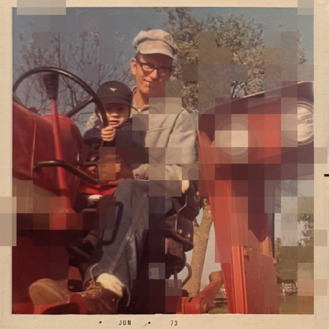 Photo of older man and young girl riding a tractor