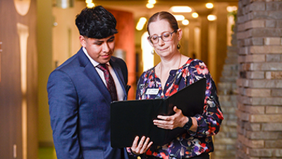 Student and faculty member looking at a book