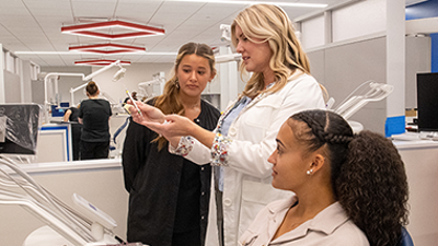 Faculty member with students in dental clinic