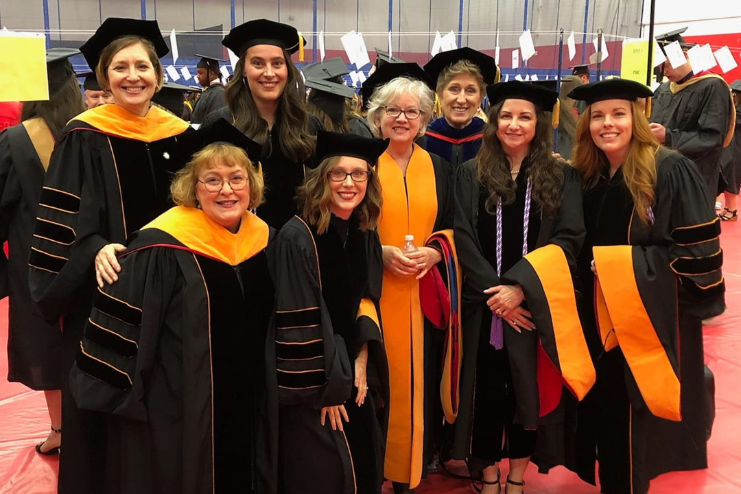 Advanced nursing practice graduates and faculty members pose in their commencement regalia