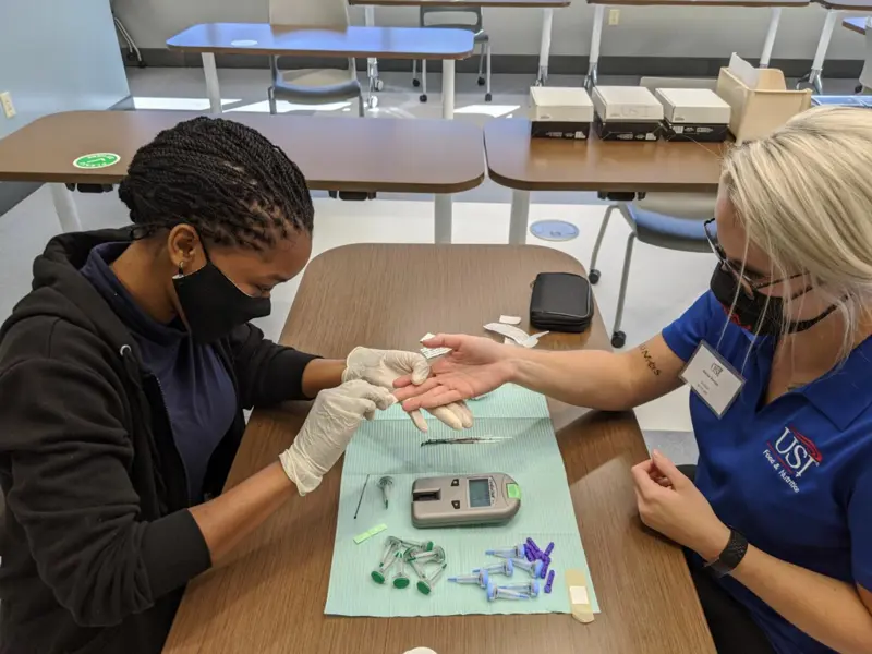 Student using needle to prick finger