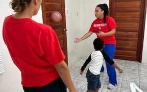 OT students playing ball with a child at the clinic