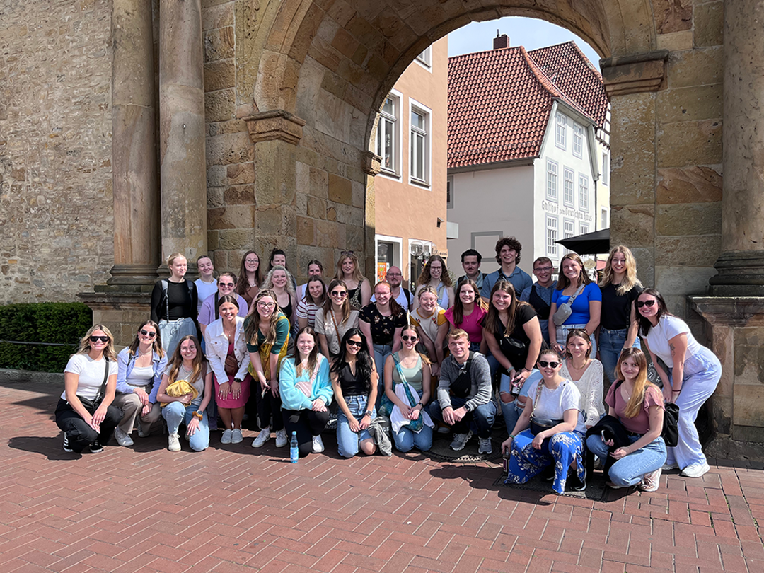 Large group of students on Germany trip in front of an archway