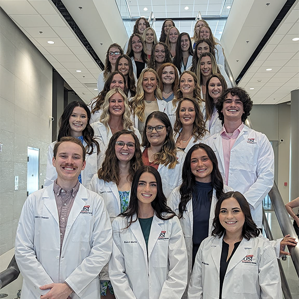 OT students in white coats on steps