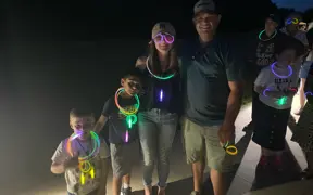 Group of attendees at night wearing glowing necklaces and bracelets.
