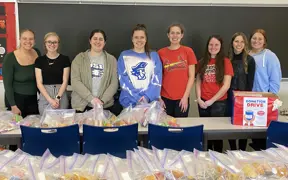 Students with assembled food bags to donate