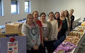 Students standing next to the food donation box