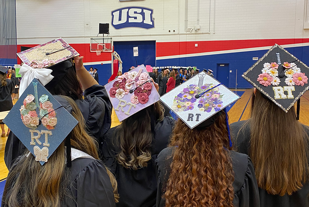 Respiratory therapy students wearing decorated caps at graduation