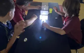 Students investigate the properties of light during a hands-on science experiment.