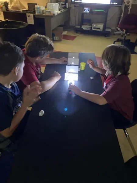 Students investigate the properties of light during a hands-on science experiment.