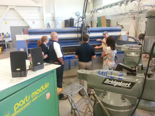 Business owners standing around machinery in the Applied Engineering Center