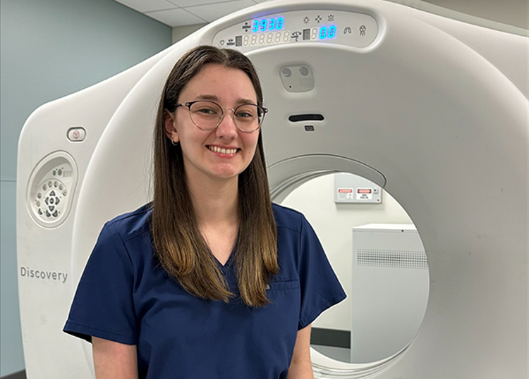 USI radiology student Grace Range sitting in front of CT simulator