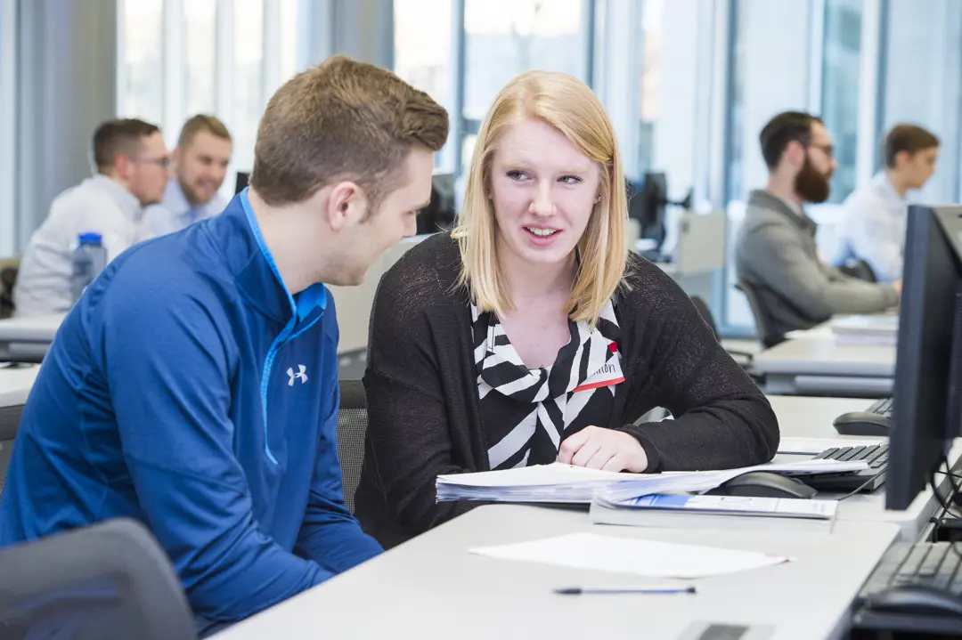 Two students work on finance schoolwork