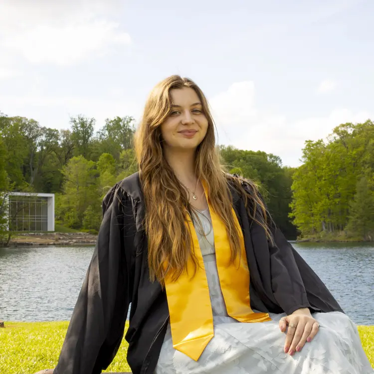 Casual portrait of USI political science and pre-law graduate Rebekah Hamilton '24 in commencement regalia