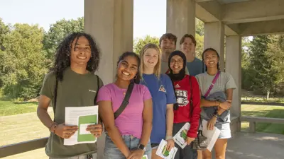 Group of new students from various racial and ethnic backgrounds pose outdoors