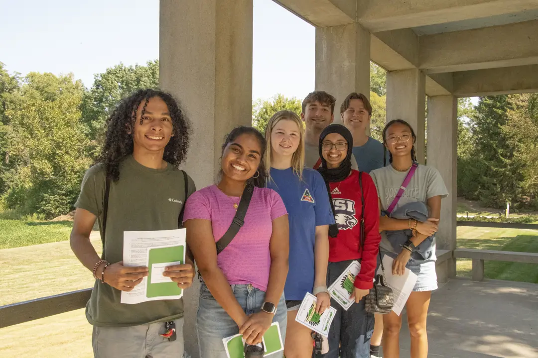 Group of new students from various racial and ethnic backgrounds pose outdoors