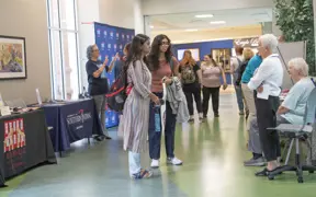 Social work students speak with older adults at a resources fair in the University Center