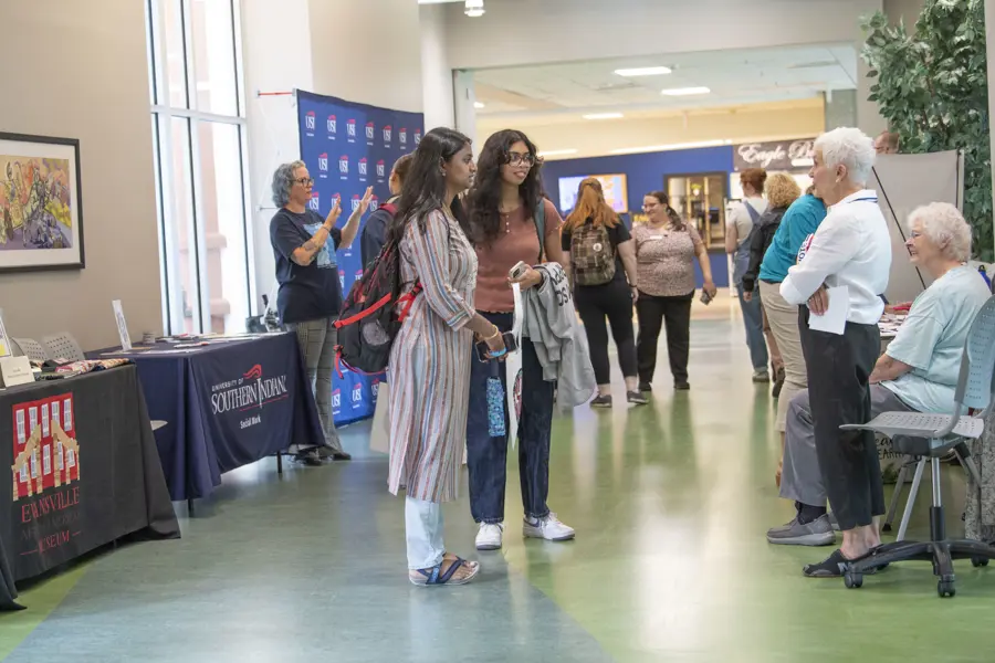 Social work students speak with older adults at a resources fair in the University Center