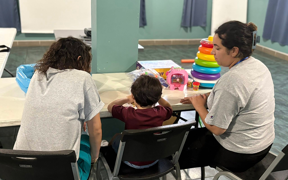 OT students working at a table with a child