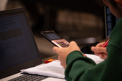 A student holds a calculator
