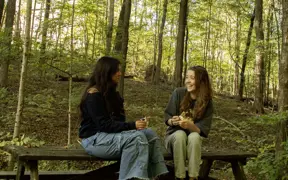 Students sit and talk on one of the three picnic tables found on the lakeside Oak Trail. 