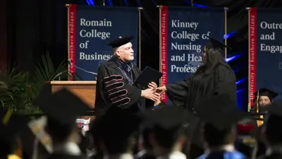 President Bridges shaking a student's hand at graduation