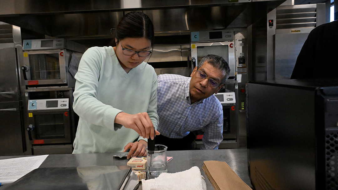 Faculty observing student in Food Science class
