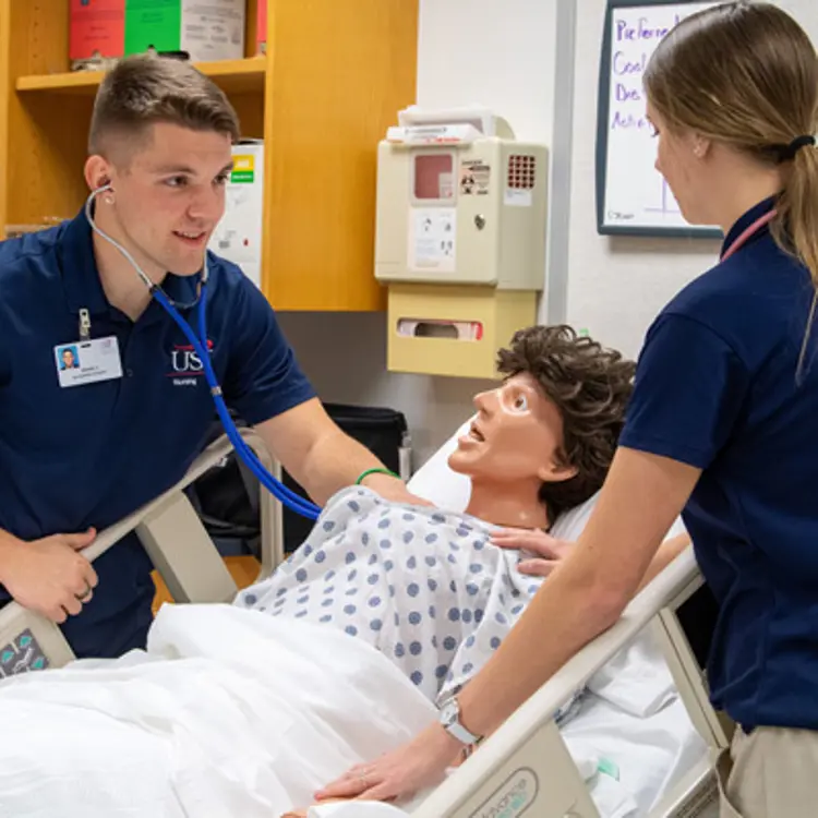 Nursing students caring for mannequin patient