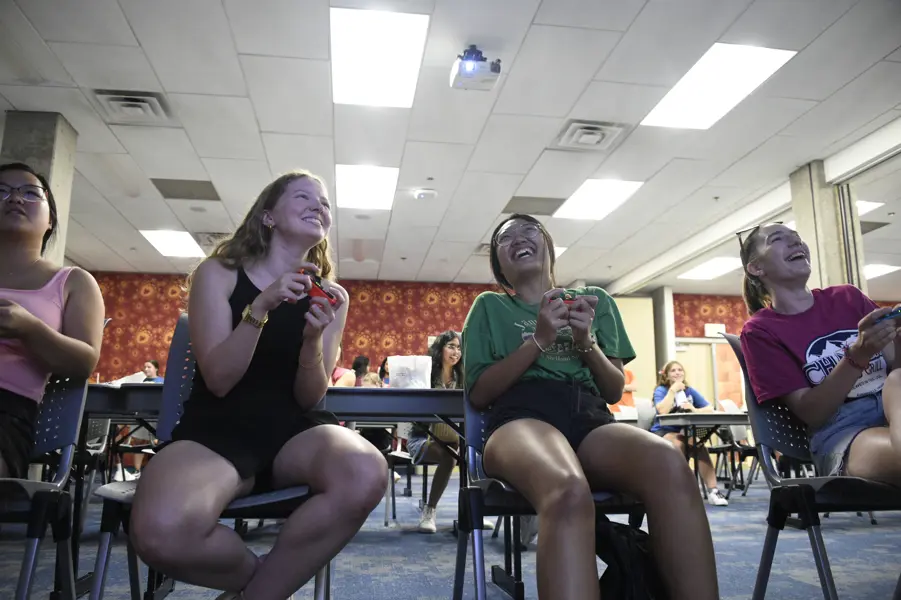Students laugh together as they sit in a University Center meeting room