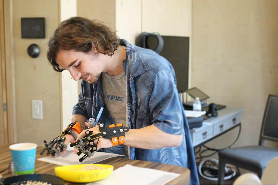 Student wearing simulation devices on his hands while trying to eat a meal