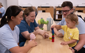 OT students helping child stack blocks