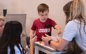 Child playing with OT students