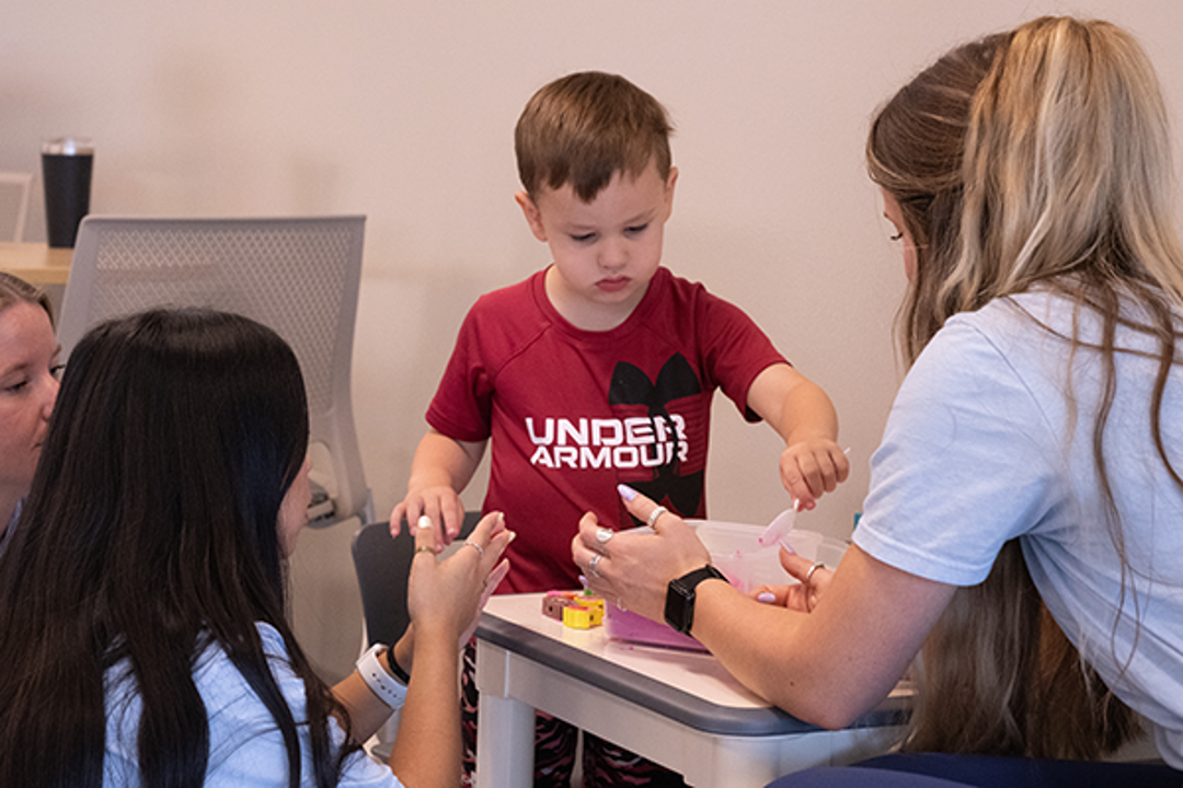 Child playing with OT students