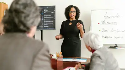 A woman teaches a professional development class to two older women