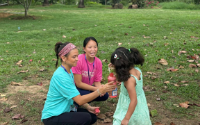 Students blowing bubbles with a child