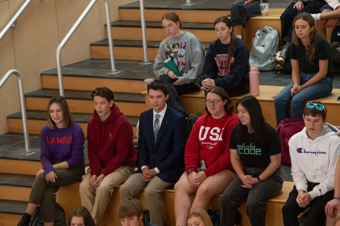 A group of students watch a presentation in the atrium of the Business and Engineering Center