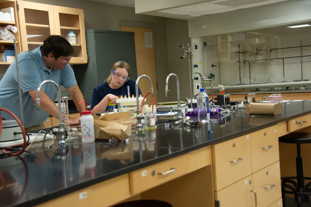 Students wearing safety goggles work in a chemistry lab