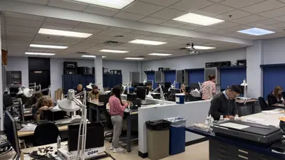 Students working at computers and on set design mock-ups