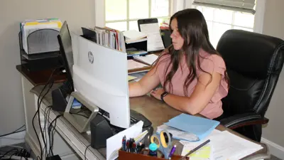 Student workin at a desk in an office