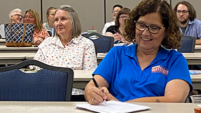 Adult learners attend a continuing education workshop and take notes