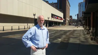 Dr. Dave Black, associate professor emeritus of Radio-Television, stands on the sidewalk in downtown Evansville