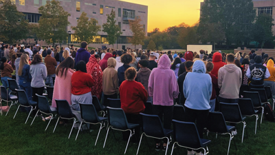 Large group of students participate in a sunset worship ceremony on the Quad