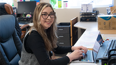 Candid photo of USI public health graduate Lauren Blank working on a laptop computer