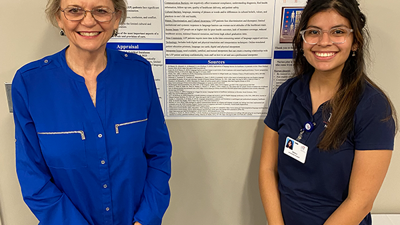 Pam Thomas with nursing student in front of poster