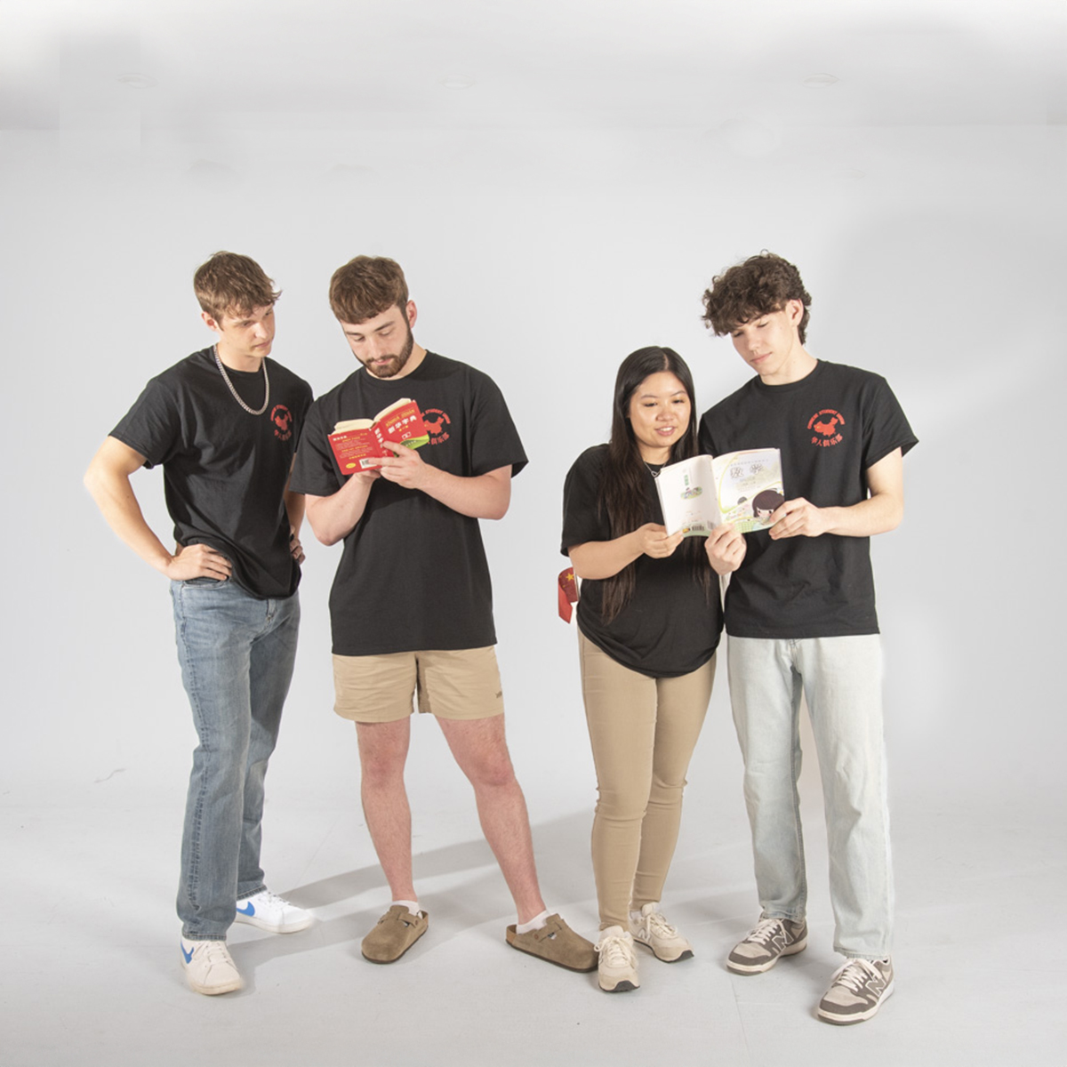 Members of the Chinese Student Union pretend to look at Chinese children's books for their group photo in the photo studio.