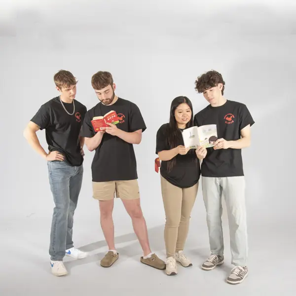 Members of the Chinese Student Union pretend to look at Chinese children's books for their group photo in the photo studio.