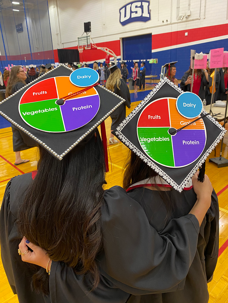 Students wearing decorated caps at graduation