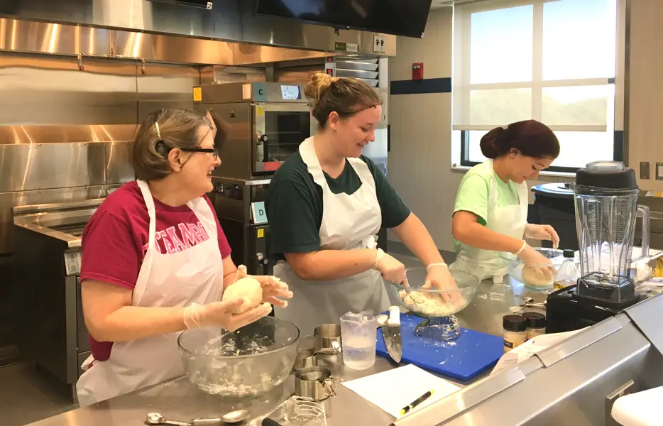 Students making dough in the quantity food kitchen