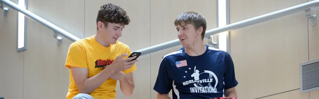 Two students chat in the Atrium of the Business and Engineering Center