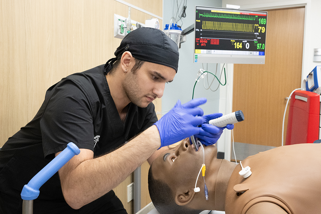 Student in scrubs intubating a practice patient in the simulation center